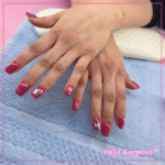 Hands showing muted red square nails with gold lines and butterflies as accents.